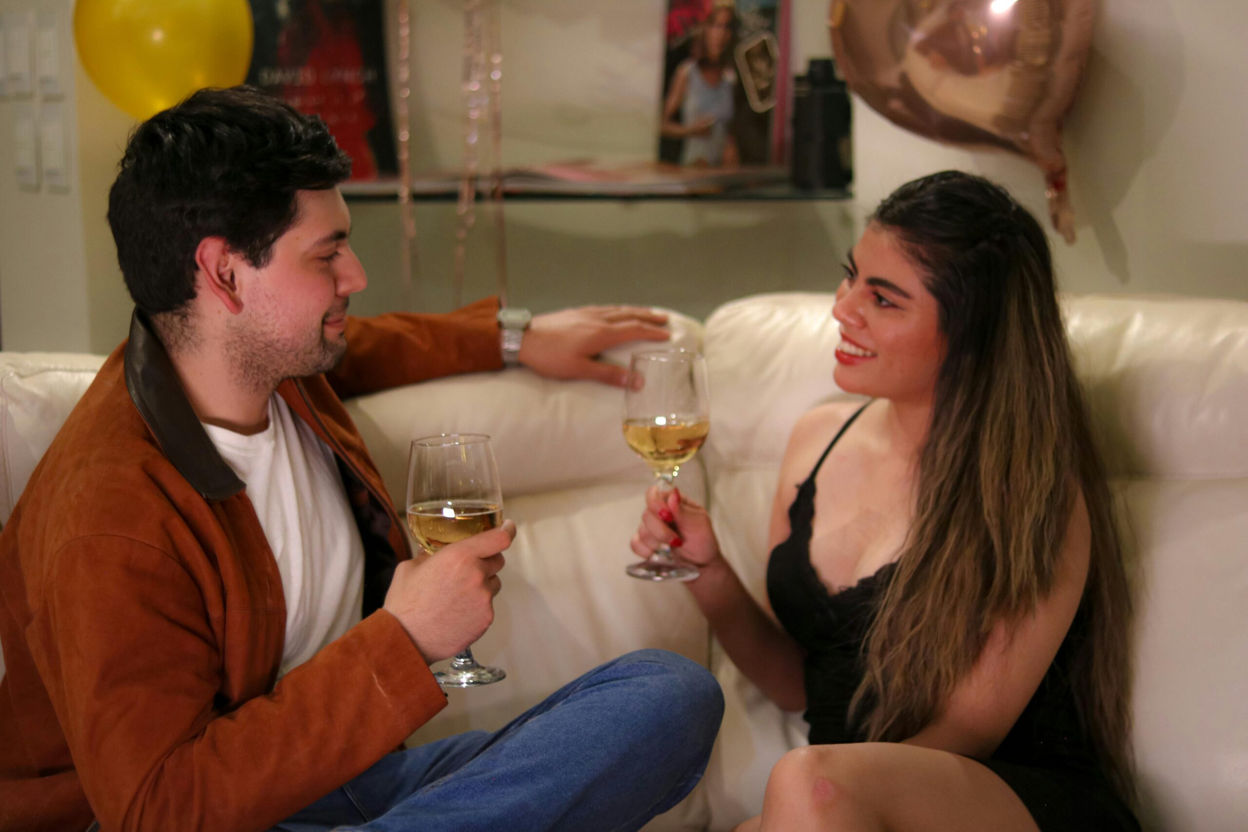 A person holding a wine glass in a confident, relaxed setting