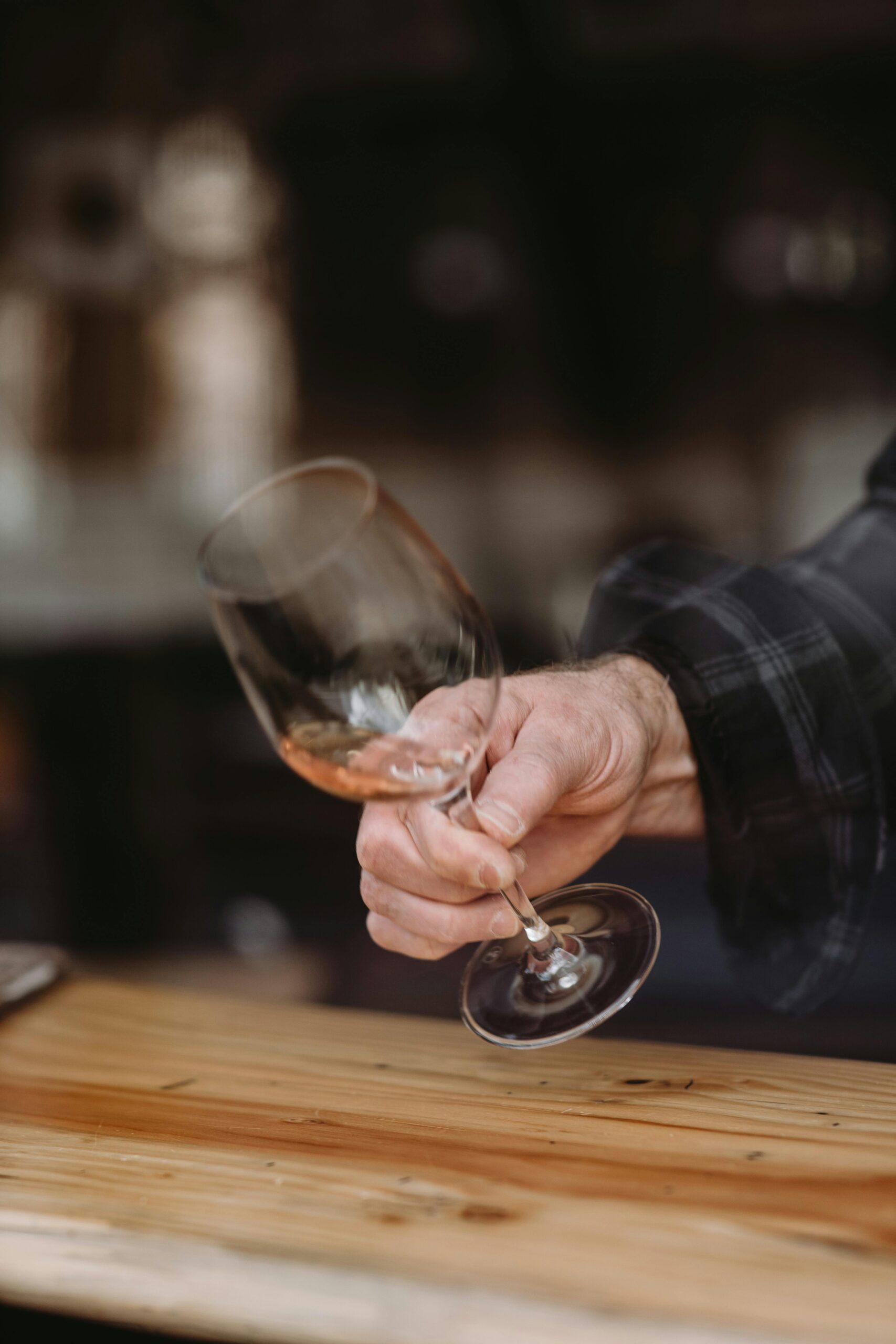 A person holding a wine glass properly by the stem